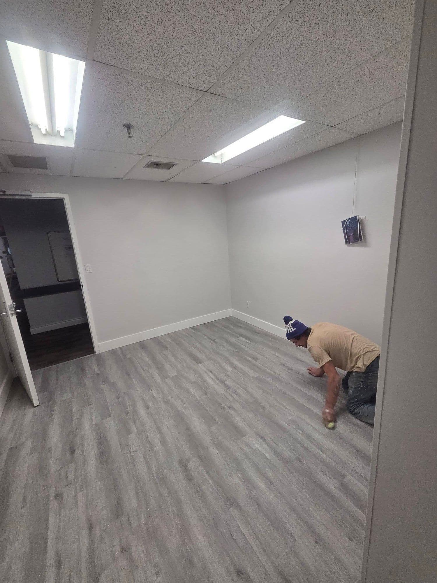 Installer laying new flooring in a renovated commercial room